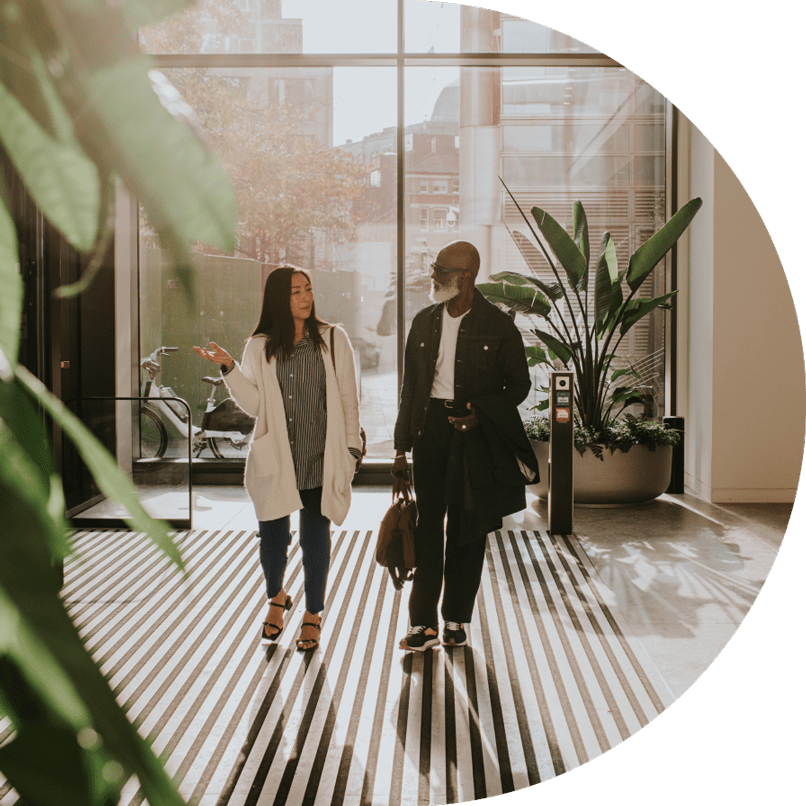 Asian woman and Black man walking in corporate building
