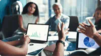people-sitting-in-a-meeting-looking-at-graph-on-laptop