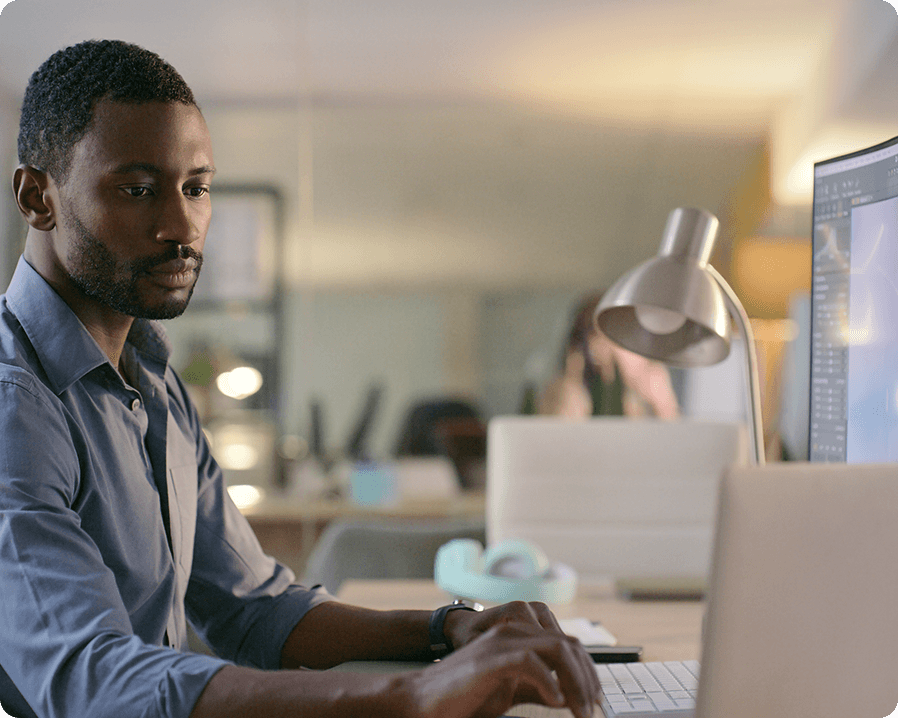 Image of a man sitting at a desk, typing on a computer