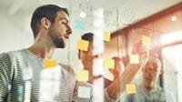 Agile-certified project professionals organizing tasks in a scrum.