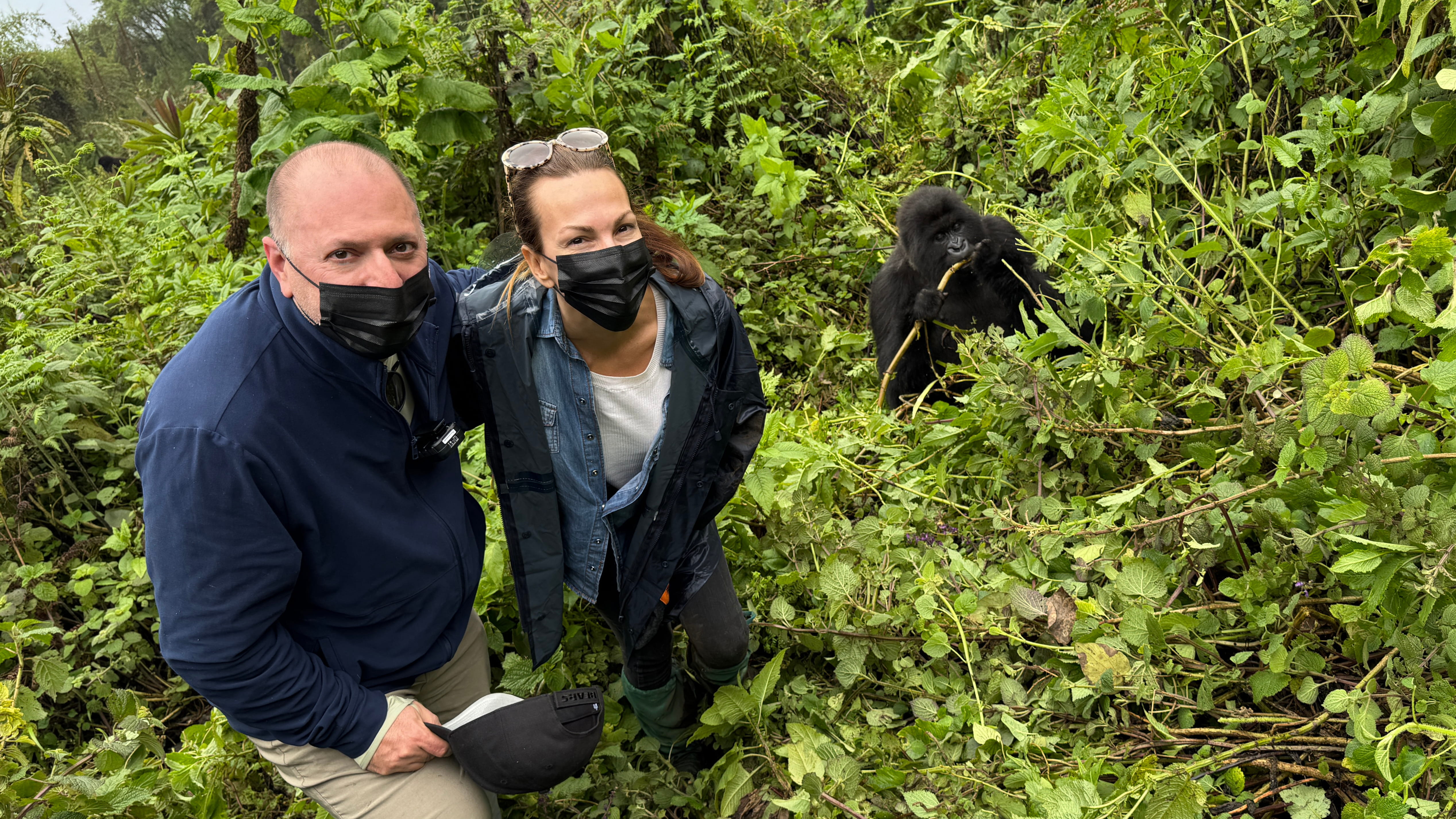 two-people-with-masks-on-standing-next-to-gorilla