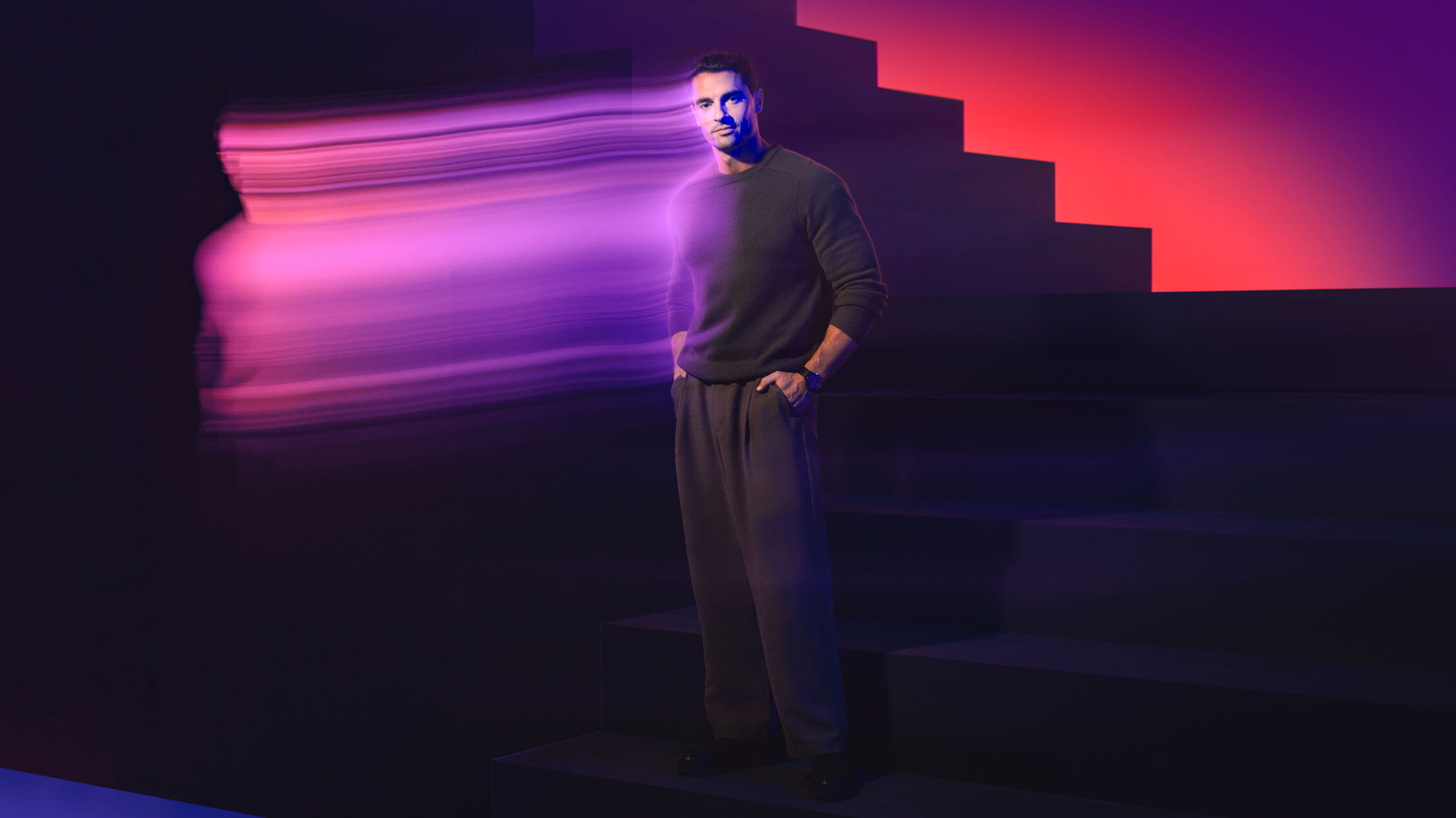 man-standing-next-to-stairs-with-purple-pink-gradient