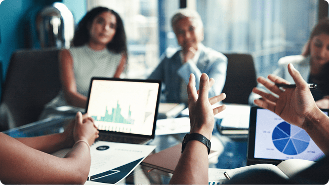people-sitting-in-a-meeting-looking-at-graph-on-laptop