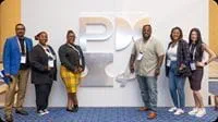 Event attendees standing beside the PMI display.