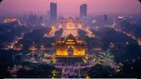 Illuminated India Gate and New Delhi cityscape at dusk.