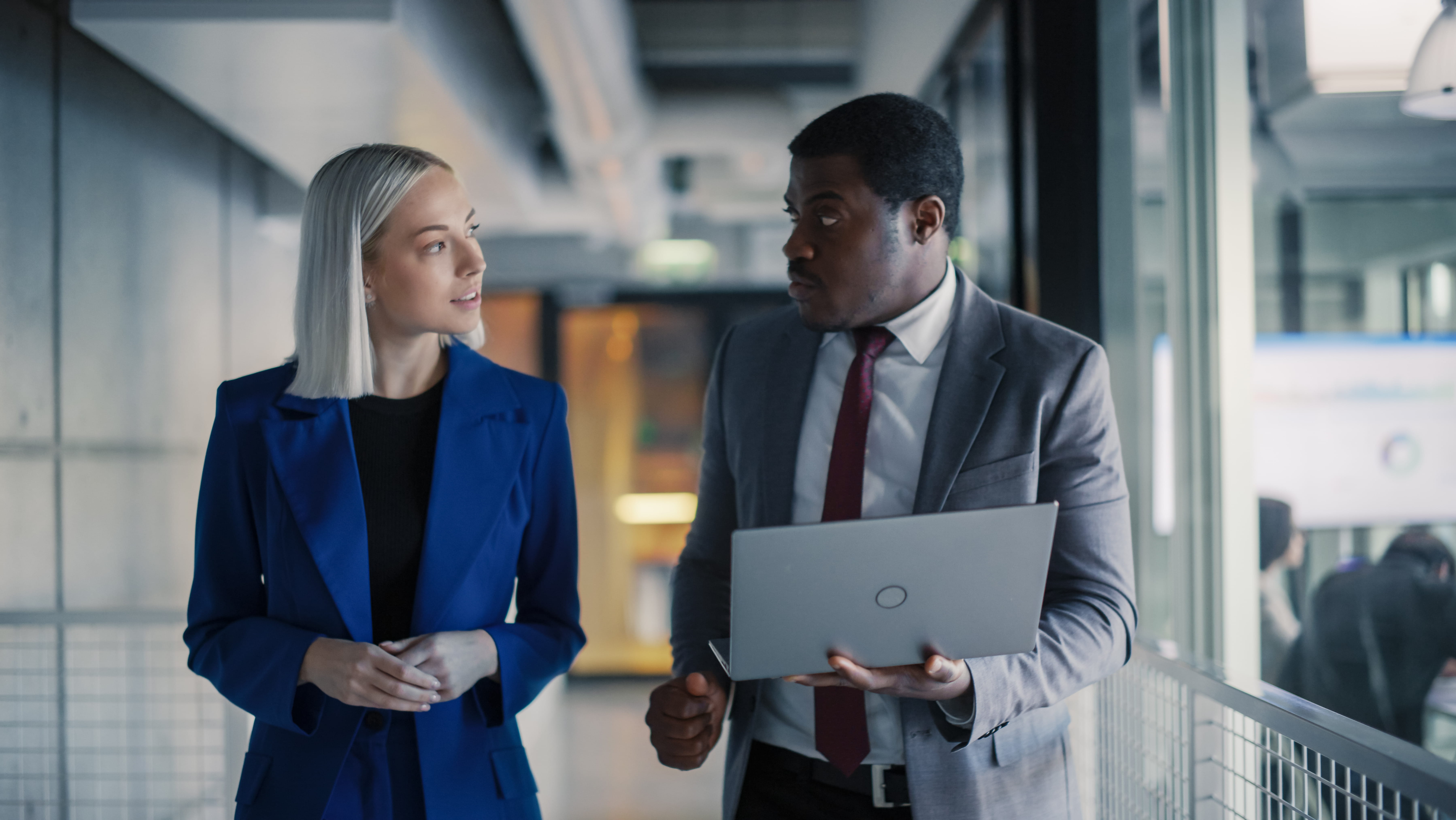 man-and-woman-talking-with-laptop-in-hand
