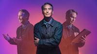 man-standing-with-arms-crossed-in-front-of-purple-pink-gradient