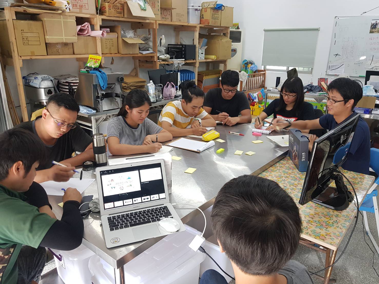 Group of students sitting around table with laptops