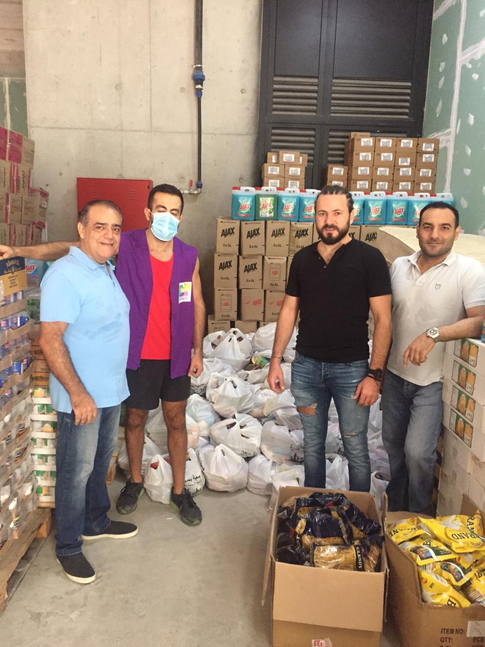 H4I-rebuilding-community-lebanon-men-standing-boxes