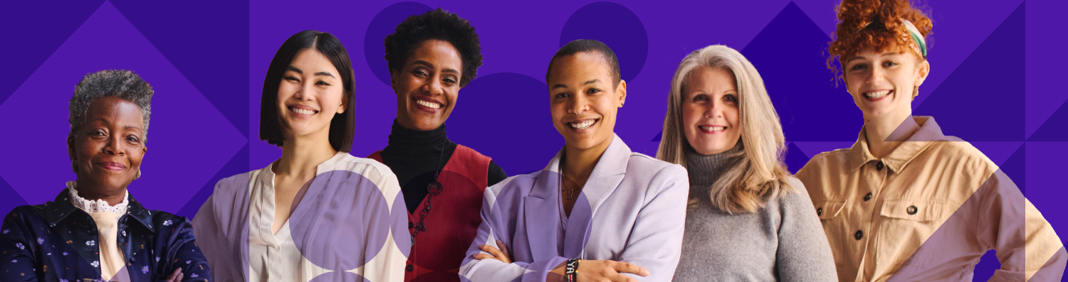 Four women, in brightly colored shirts, smiling at the camera