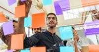 man-writing-on-colorful-sticky-notes